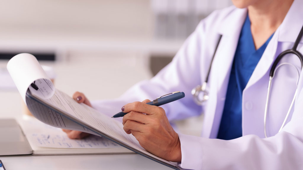 Chirurgien orthopédique consultant les données patient sur tablette avant une consultation